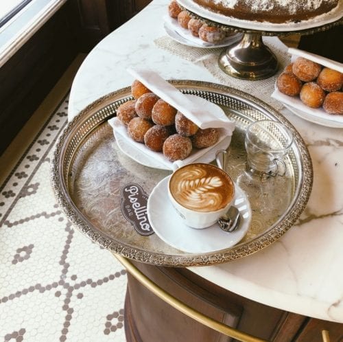 cappuccino and bomboloni on a silver tray at bar pisellino