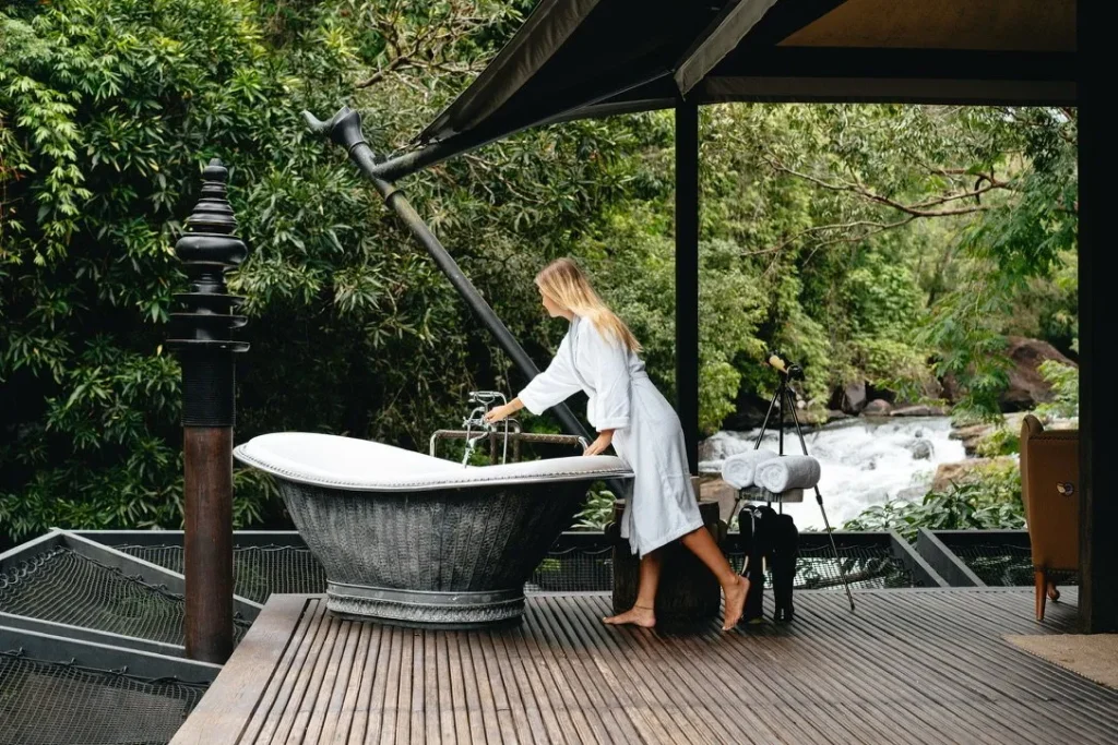 Open-air copper bathtub in Cambodia rainforest luxury resort.